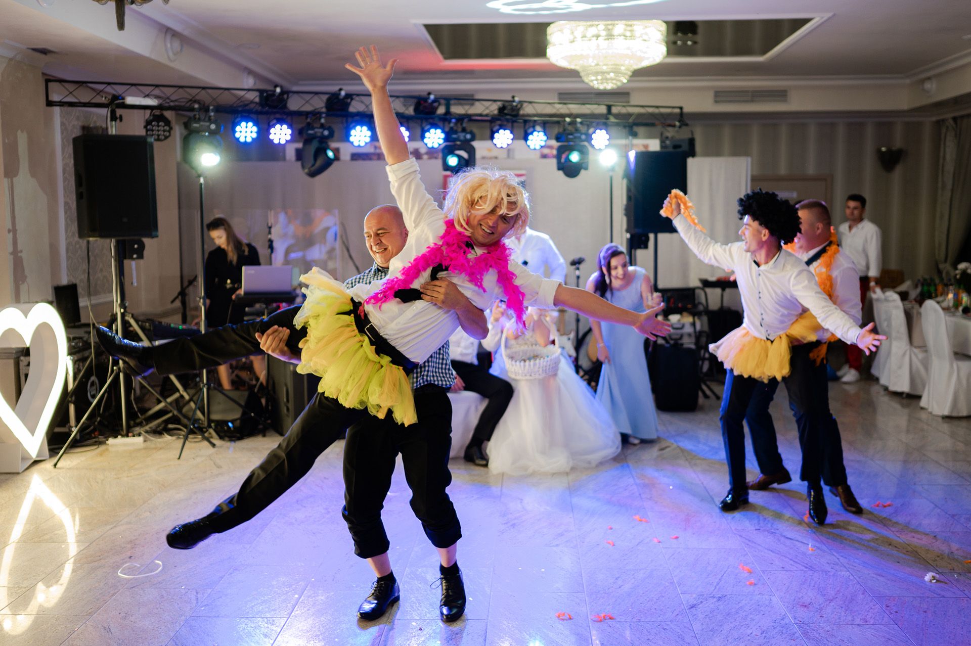 Kabaret weselny z gośćmi w przebraniach i kolorowych kostiumach, rozrywka i zabawy podczas przyjęcia ślubnego