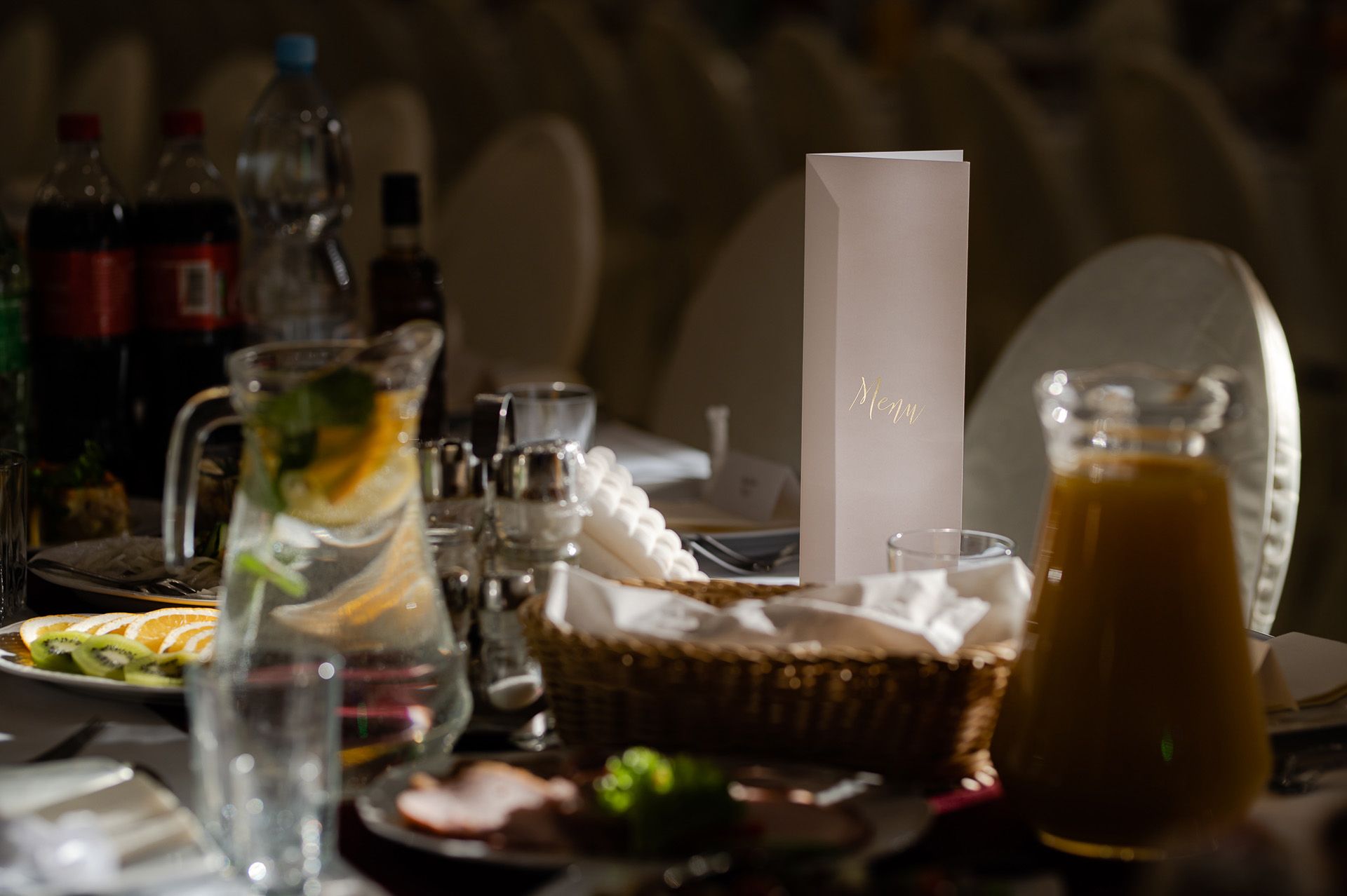 Elegancki stół weselny z menu, lampką, talerzami i dekoracjami, przygotowania obiadu ślubnego w restauracji